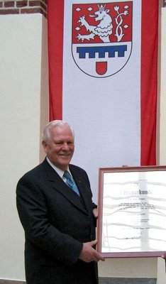 Ehrenbürger Hans Schmitz mit Ehrenbürgerurkunde und Stadtwappen